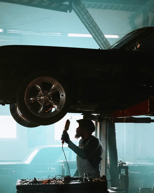 A mechanic searching the underside of the car.