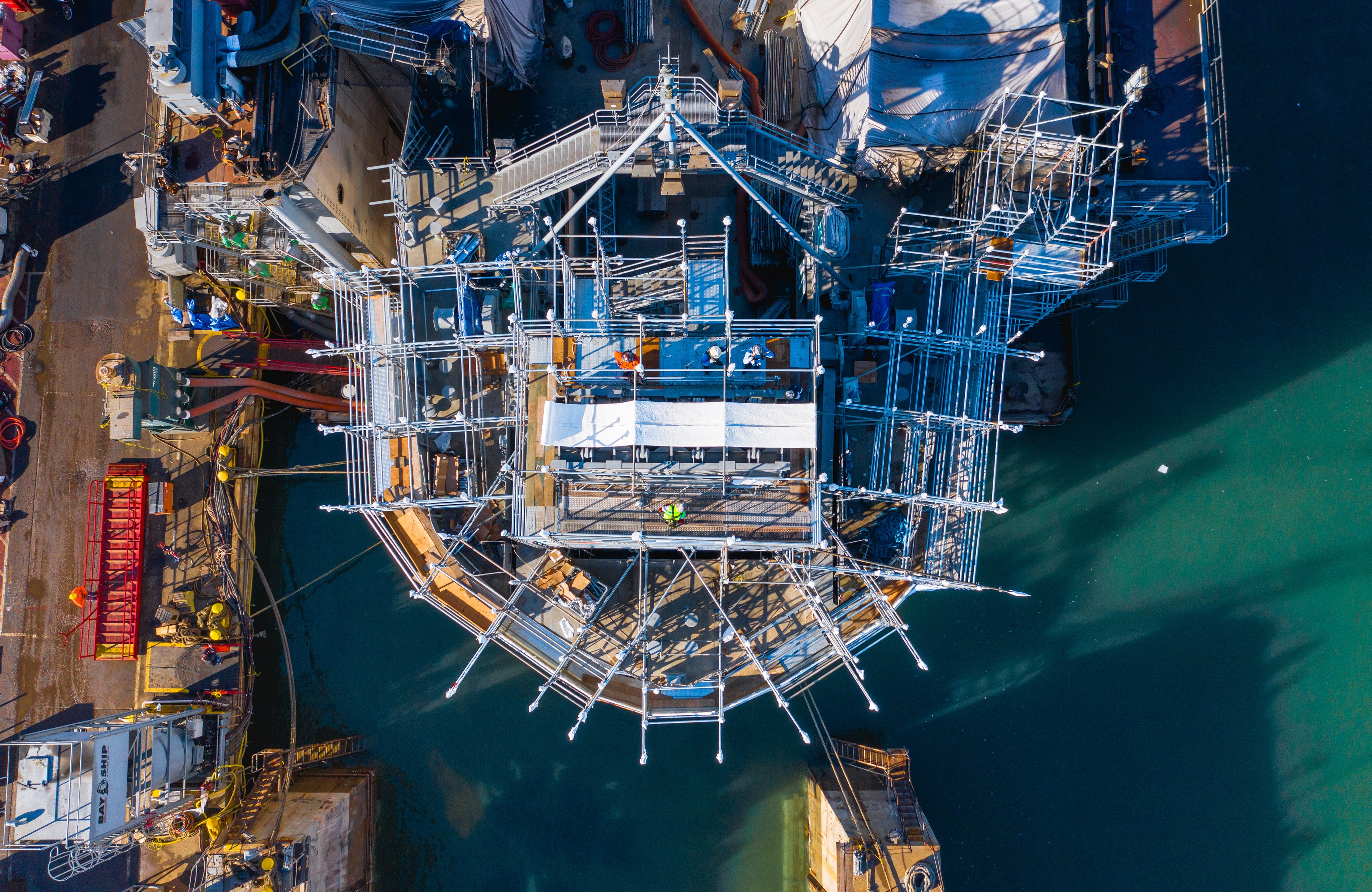 Top down view of construction being done on a ship.