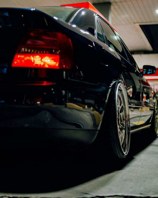Black car parked inside a garage with red accents